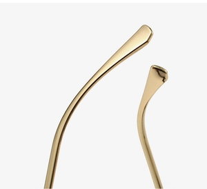 Macro shot of polished gold metal temple tips on trendy cat-eye blue light glasses