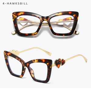 Detail of tortoise cat-eye frames with heart-shaped accents on gold metal temples