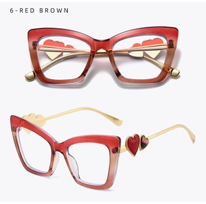 Detail of red brown cat-eye glasses frame featuring a gold temple with a red heart motif
