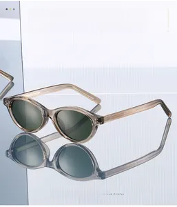 Detail of oval sunglasses with translucent tea frames and dark green lenses on reflection