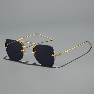 Frameless polygonal metal sunglasses with dark lenses and gold frames on gray background