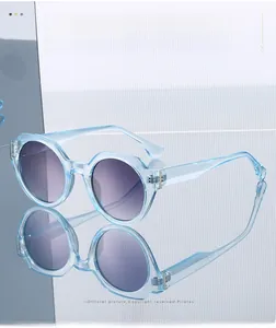 Detail of light blue transparent round sunglasses with purple gradient lenses on reflection