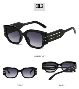 Detail of round sunglasses with black frames and golden accents and purple gradient lenses