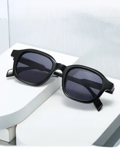 Vue détaillée de lunettes de soleil noires brillantes sur un présentoir minimaliste