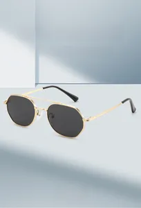 Detail of trendy double-bridge metal sunglasses with hexagonal gold frames and dark lenses