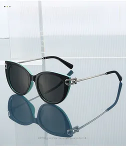 Cat-eye sunglasses with dual-color frame and metallic chain-link detail on reflective glass
