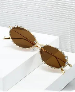 Detalle de gafas de sol ovaladas de metal de lujo con incrustaciones de pedrería
