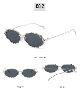 Detalle de gafas de sol ovaladas de metal plateado con montura de pedrería y lentes oscuras