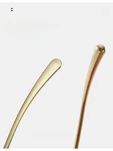Close-up of curved golden metal temples on minimalist oval sunglasses for comfort