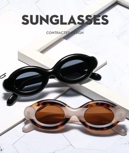 Detail showing classic black and tortoise shell oval sunglasses on marble background