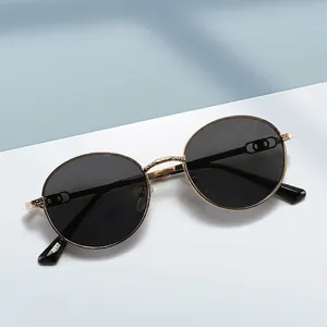 Vintage round metal sunglasses with gold frame and dark lenses shown from a top view