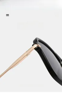 Detail of square pilot sunglasses showing durable gold metal hinge and elastic black frame