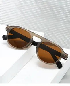 Detail of retro round TR90 sunglasses with brown lenses on a white stone background