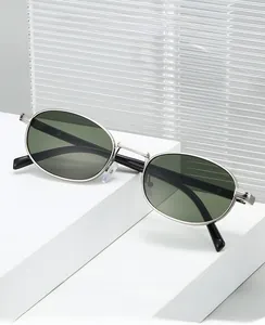 Detail of silver oval frame sunglasses with dark green lenses on geometric display