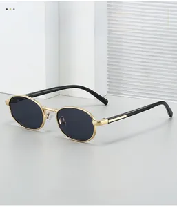 Detailed macro view of oval sunglasses featuring gold metal frame and dark lenses