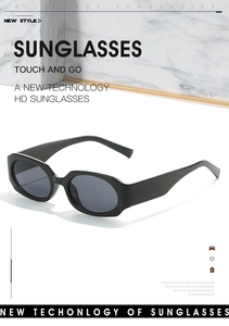 Detailed view of gloss black oval sunglasses with thick frames on a marble display