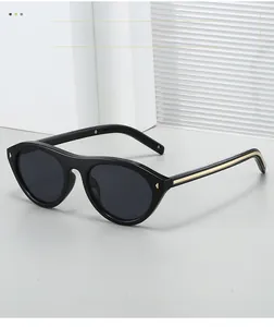 Detailed view of black oval sunglasses with sleek golden metal trim on the temples