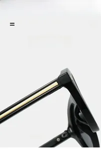Detail of sleek black sunglasses hinge with parallel golden metal stripes decoration