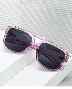 Detail of square pilot sunglasses featuring purple frames and gold metal hinge accents