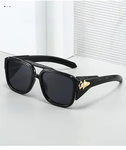 Close-up of golden insect decoration on the temple of black square frame sunglasses