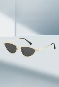 Détail de la monture oeil-de-chat en métal doré avec texture fine et verres foncés chic