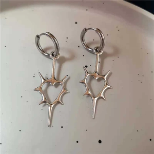 Boucles d'oreilles cœur argent Y2K avec pointes et design punk sur plateau blanc