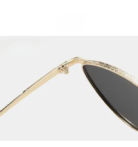 Détail des charnières robustes en métal doré sur lunettes de soleil œil-de-chat noires