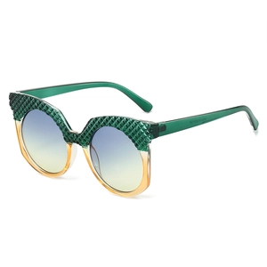 Oversized oval cat-eye sunglasses with green textured frame and gradient lenses