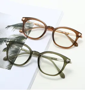 Detail of vintage round TR frames in amber and olive green on a magazine background