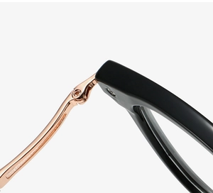 Macro shot of the precision rose gold metal hinge on minimalist black round glasses frames