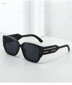 Close-up of black cat-eye sunglasses with gold metal accents and temple details