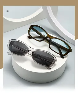 Close-up of rectangle sunglasses in transparent grey and olive green on a display stand
