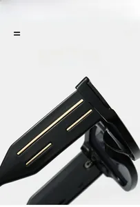 Detail of sleek black sunglasses temple with parallel gold metal accents on white backdrop