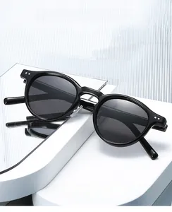 Detail of black TR90 polarized round sunglasses on a mirrored stand with 2025 retro design