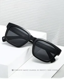 Square black polarized sunglasses on white geometric blocks with glass backdrop