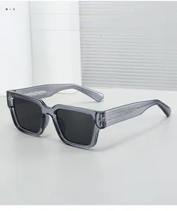 Détail des lunettes de soleil carrées gris foncé transparentes avec charnières en métal