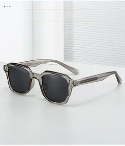 Detail of grey translucent sunglasses frame with reinforced metal hinge and dark lenses