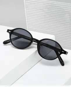 Detail of black oval frame glasses featuring a textured woven pattern on the temples