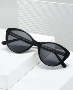 Detail of sleek black cat-eye sunglasses with polished frames on modern white steps