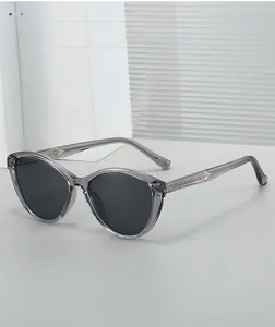 Detail view of cat-eye sunglasses with transparent gray frame and metal arrow temple accents