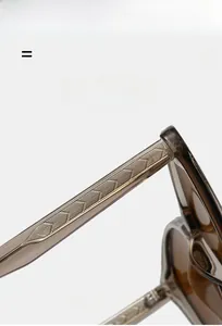 Detail of cat-eye sunglasses temple featuring textured metal core and amber acetate material