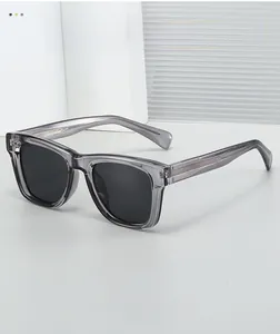 Detail of square sunglasses with transparent grey resin frame and textured metal inlay