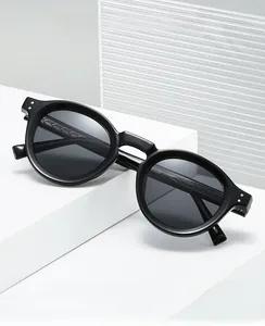 Detail shot of matte black round vintage sunglasses with silver rivet on the temple
