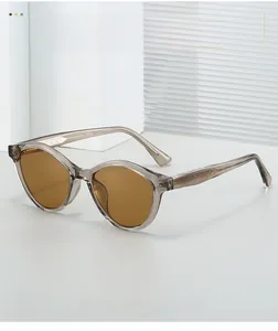 Détail de lunettes de soleil œil-de-chat thé avec branches gravées de plumes