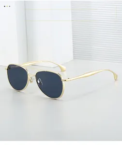 Detail of pilot sunglasses with gold metal frame and dark gray gradient lenses
