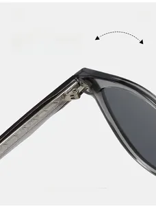 Détail de la charnière métallique de lunettes de soleil œil-de-chat noires à branches texturées