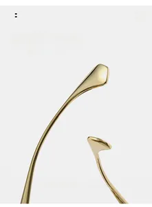 Detailed close-up of golden metal curved sunglasses temples with a polished finish