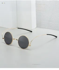 Detail of retro 1960s hippie round gold metal frame sunglasses with dark grey lenses