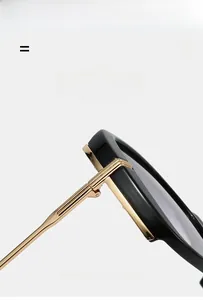 Détail des charnières en métal doré et des montures larges noires de ces lunettes de soleil