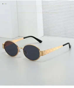 Detail of gold metal oval sunglasses featuring laser-engraved rose patterns on temples